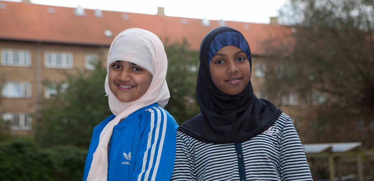to unge står og smiler