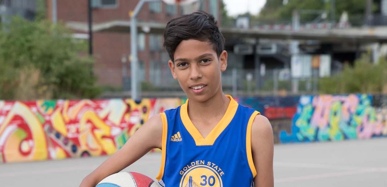 Barn står med basketball
