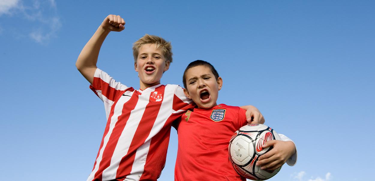 To børn står med fodbold og jubler