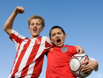 To børn står med fodbold og jubler